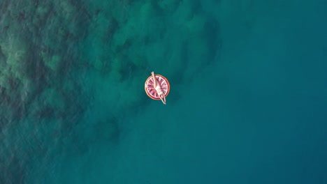 in summer the girl lies on the colorful seabed, the drone shoots upwards at sea turkey