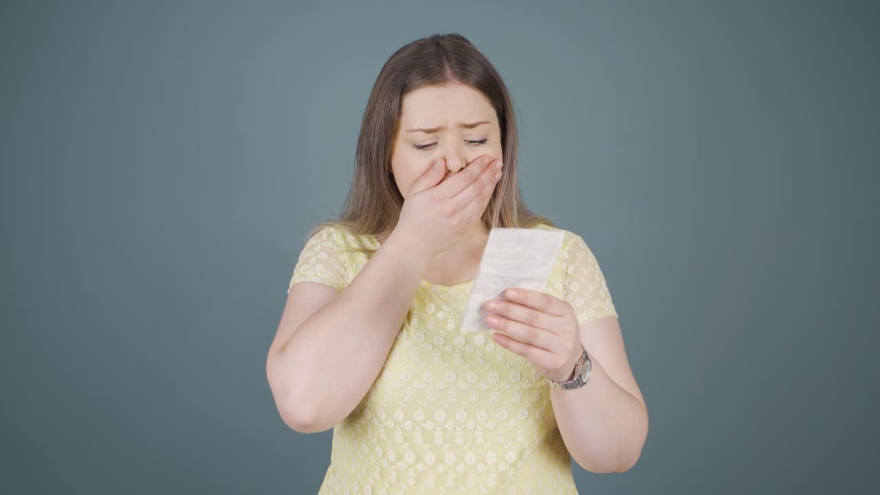 mujer joven enojada con una gran factura.