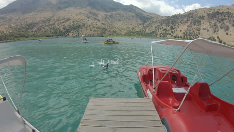 pov of lake kournas from pier, pedal boats and canoes