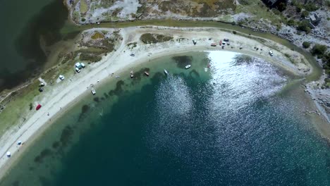 Cinematic-slowly-tilting-up-4K-drone-clip-over-the-tropical-blue-waters-of-Toroni-in-Chalkidiki