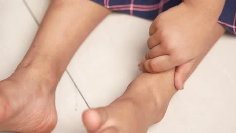 child touching ankle