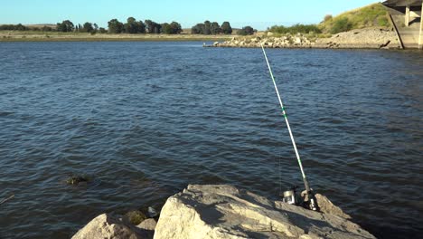 Fishing-rod-waiting-for-catch-in-Argentine-lake,-Paso-de-las-Piedras-Dam