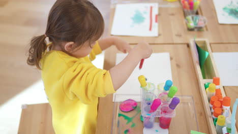 happy girl doing first drops of watercolor on paper