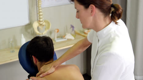 female physiotherapist giving back massage to a patient