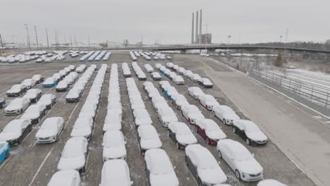 coches cubiertos de nieve volando a baja altura con revelación de la planta de montaje de automóviles