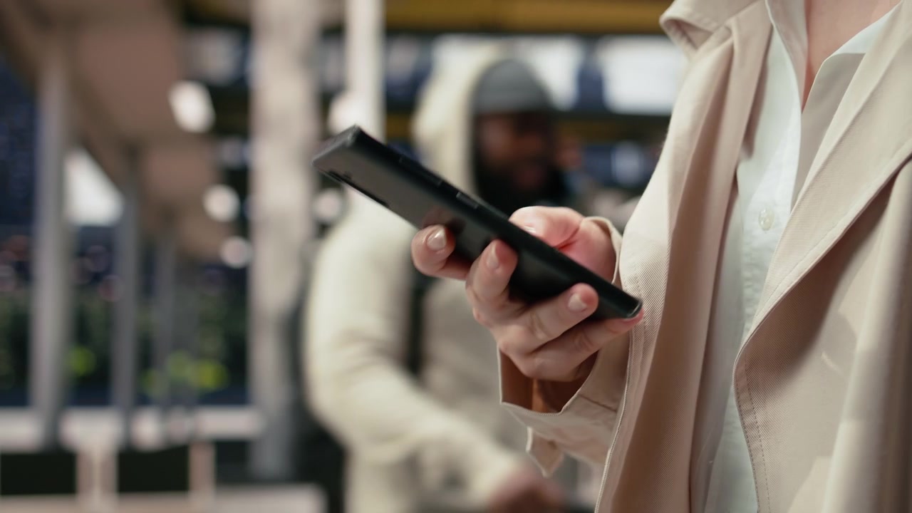 Extreme close up of traveler holding smartphone while walking in bus terminal