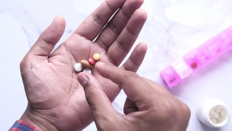 persona que sostiene varias pastillas en la mano