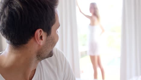hombre mirando a su novia por la ventana