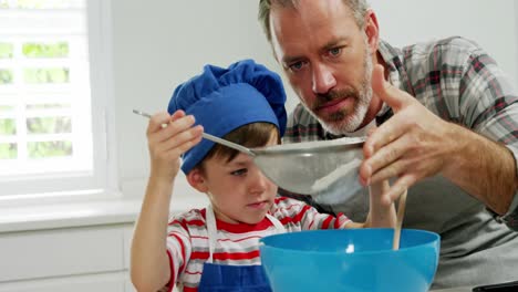 Vater-Hilft-Dem-Jungen,-Mehl-Mit-Einem-Sieb-Zu-Filtern