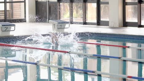 splashing into swimming pool, swimmer diving from starting block during practice