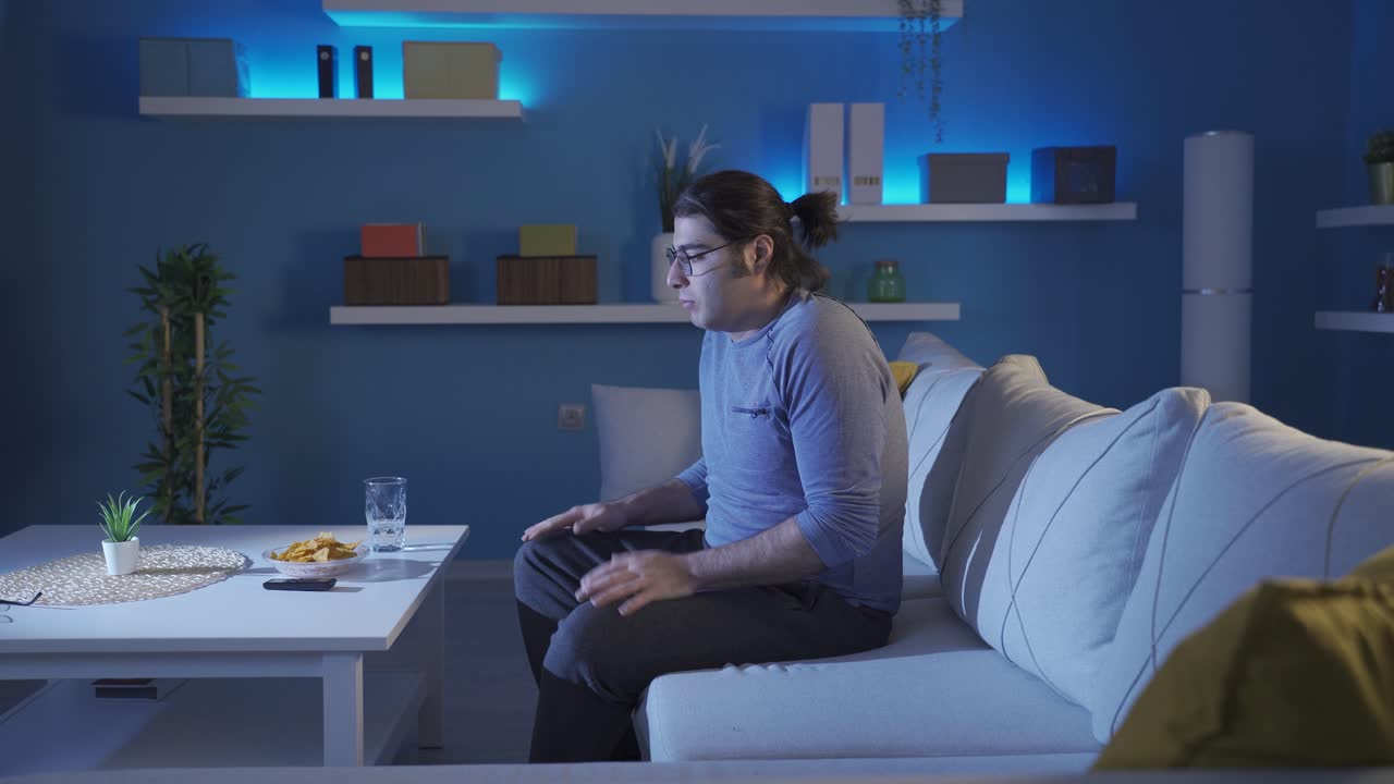 un hombre asustado solo en casa.