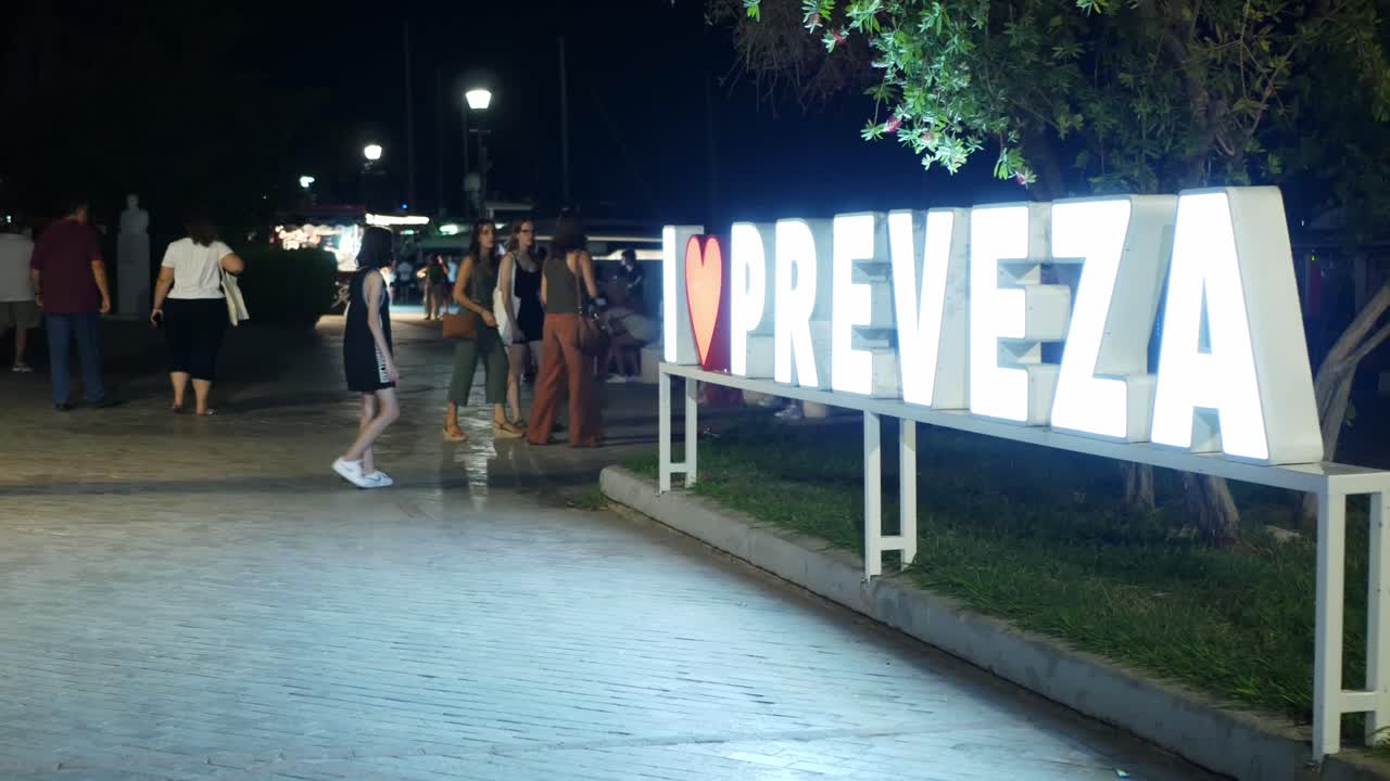 Tourists in front of the town lighted sign