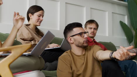 side view of a study group sitting on sofa and floor