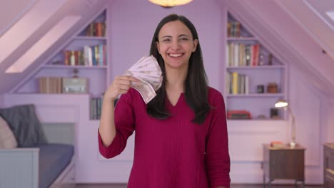 rich indian woman using money as fan
