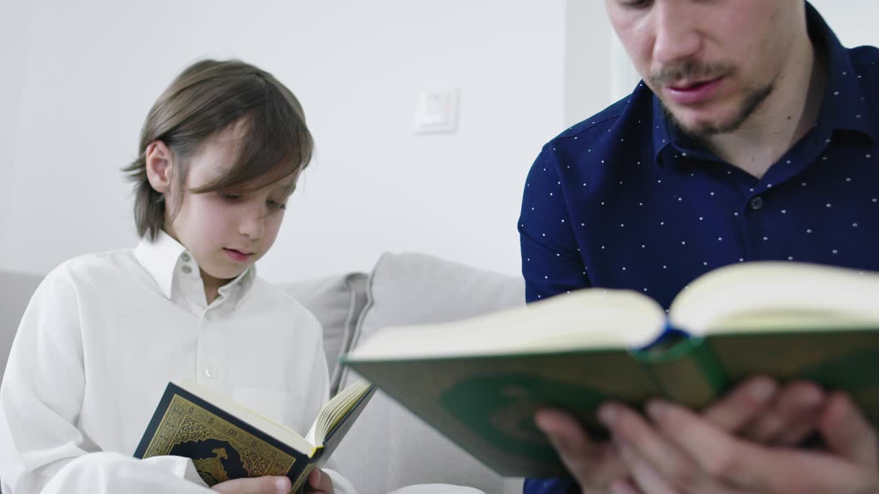 мусульманский отец и сын читают из корана во время рамадана