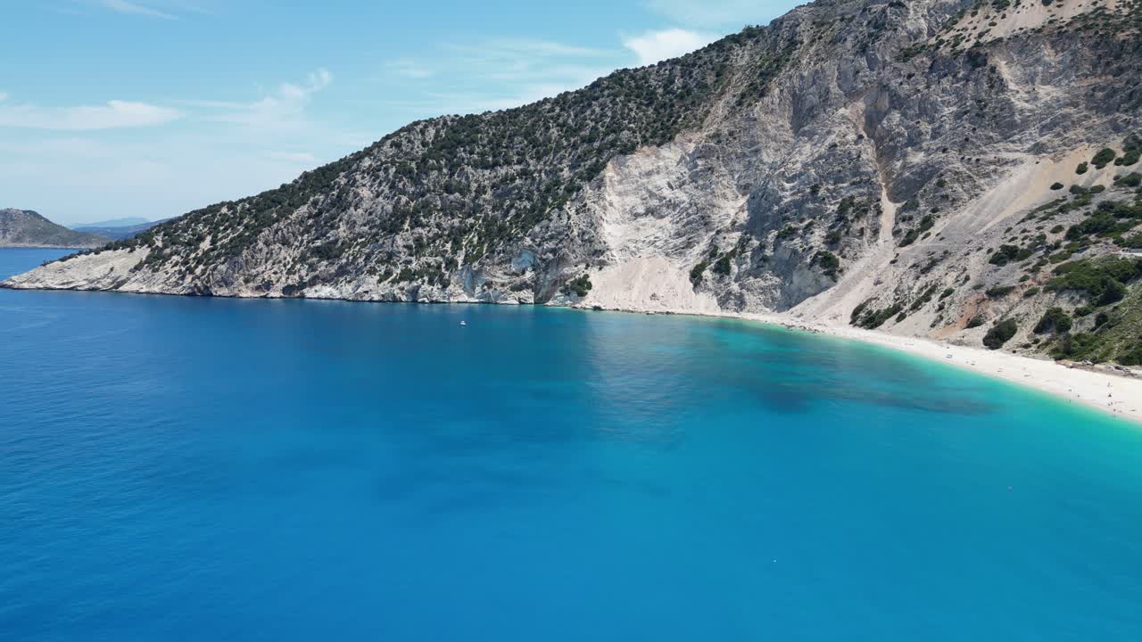 A crystal-clear Greek Blue Lagoon with a small sailboat resting quietly at anchor