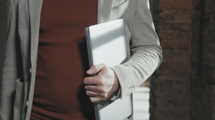 Mid-Section of Businessman with Laptop Walking through Office