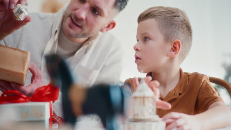 dad wraps christmas presents with his son