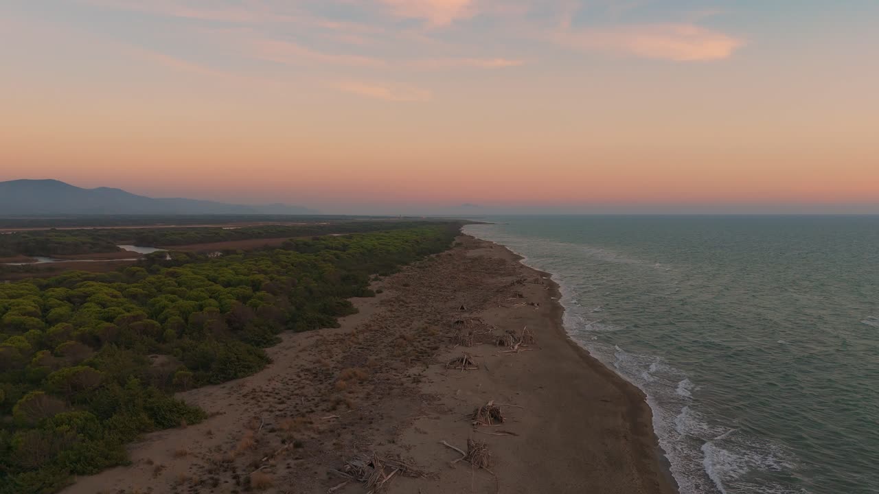Tramonto in spiaggia con cielo e mare dai colori vivaci.