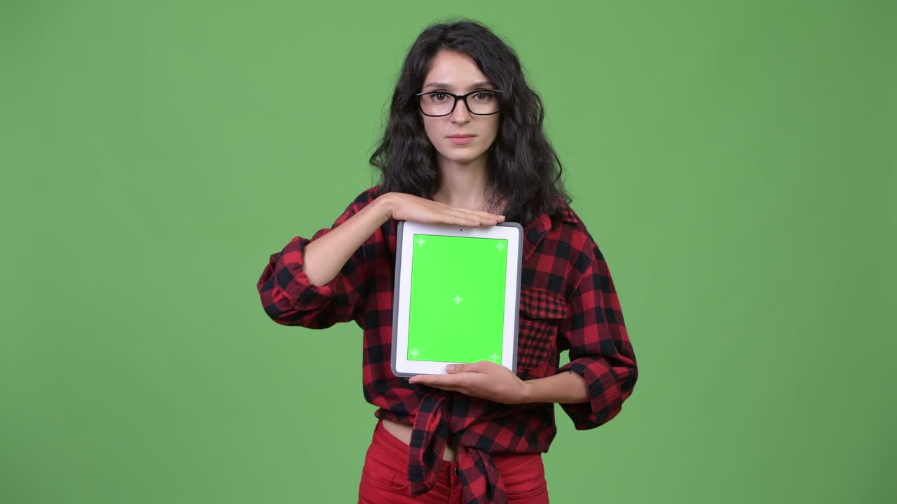 Ung, smuk forretningskvinde, der viser digital tablet