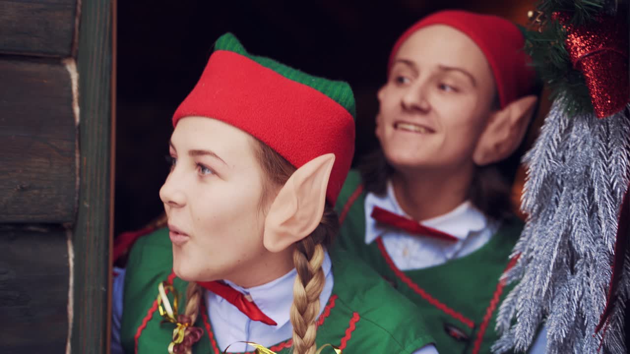 Elves opening door. Close up view of two elves opening door of Santa Claus