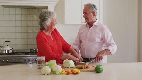 Pareja-Mayor-Caucásica-Sonriendo-Mientras-Se-Miran-En-La-Cocina-De-Casa