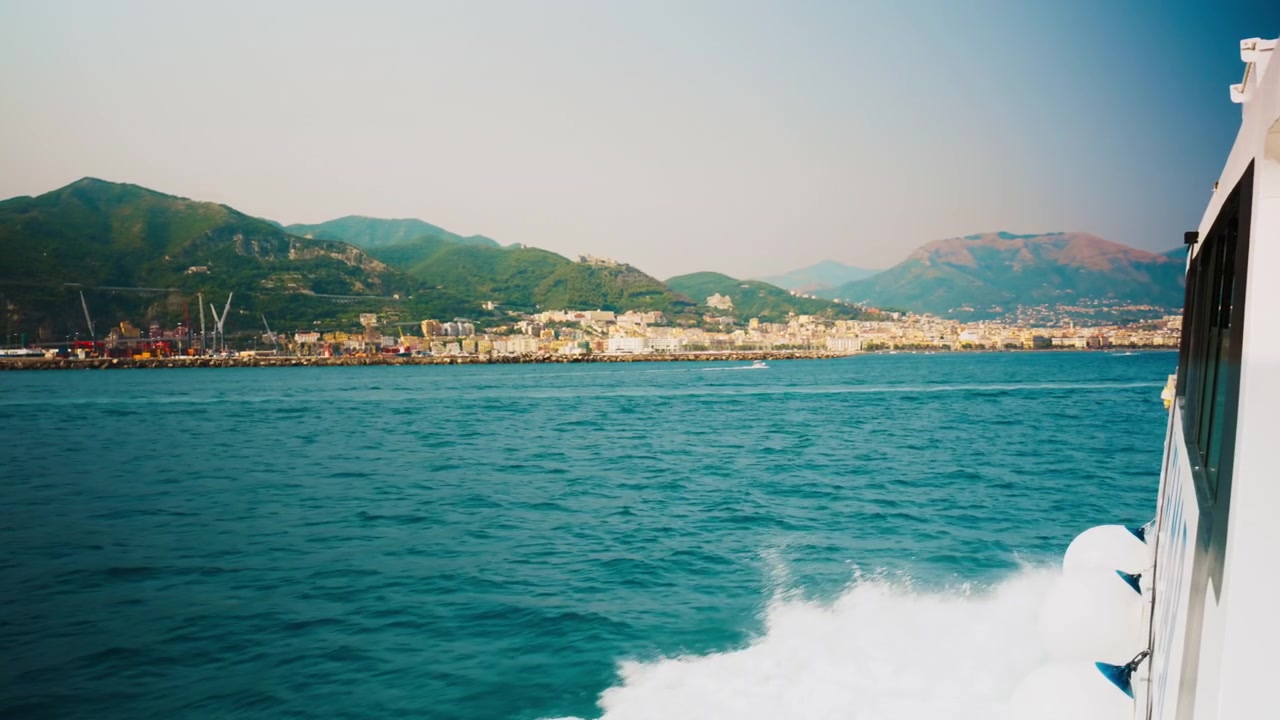 Lungomare di Salerno che si lascia alle spalle lo scafo con i parabordi di un traghetto in corsa.