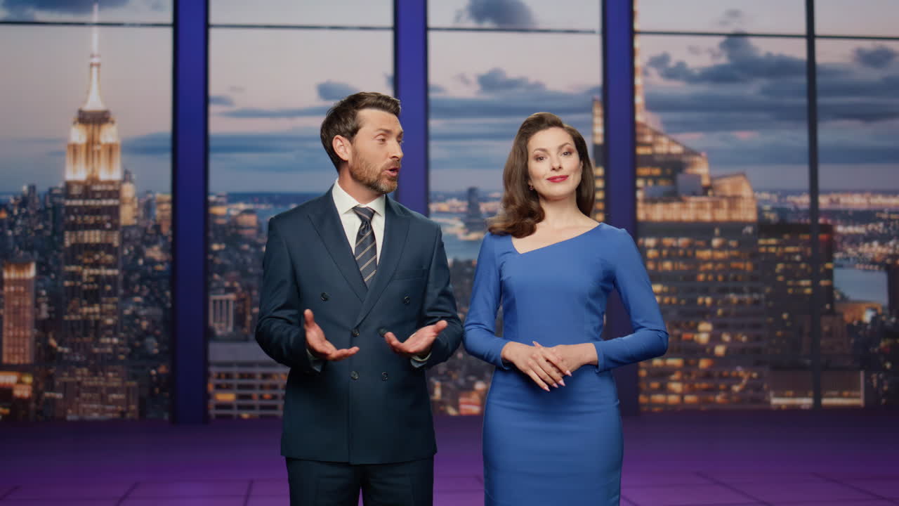 Conduttori amichevoli sorridenti in studio televisivo. Coppia di giornalisti che annunciano le notizie.
