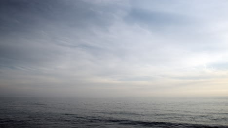 Calm-serene-blue-water-ocean-waves-of-Malibu,-on-a-cloudy-day-in-the-evening