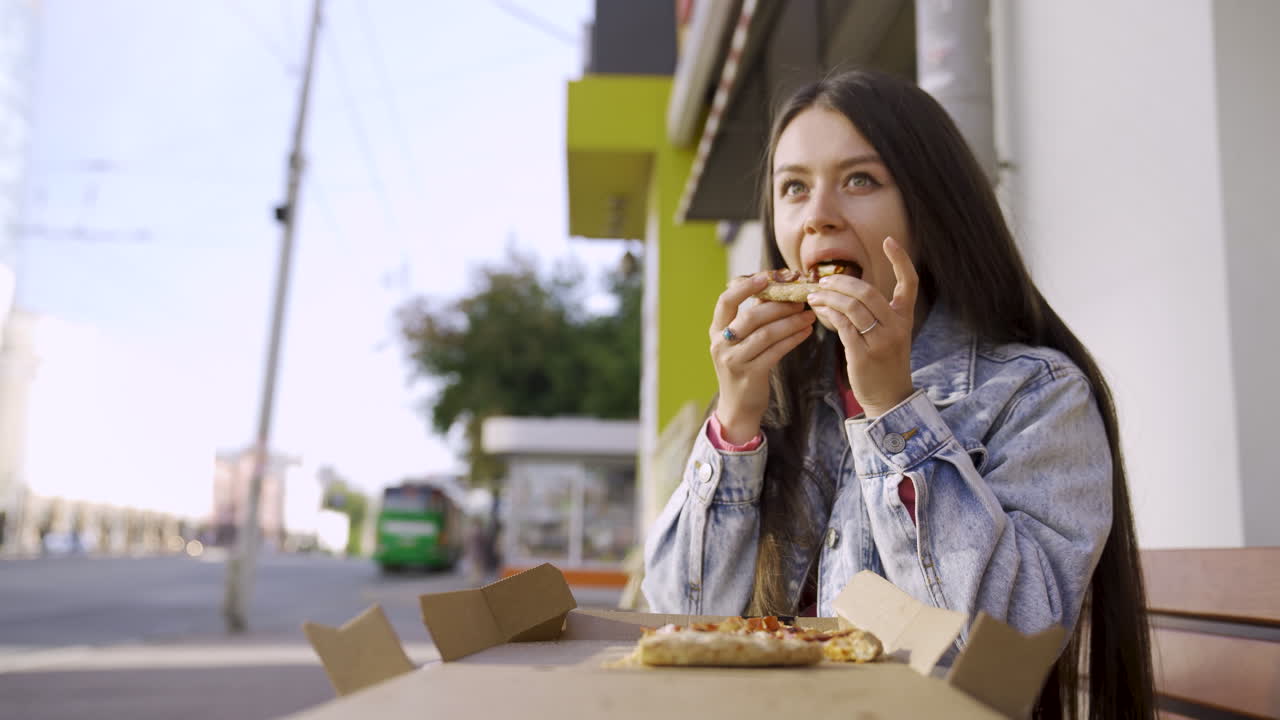 mujer comiendo pizza al aire libre