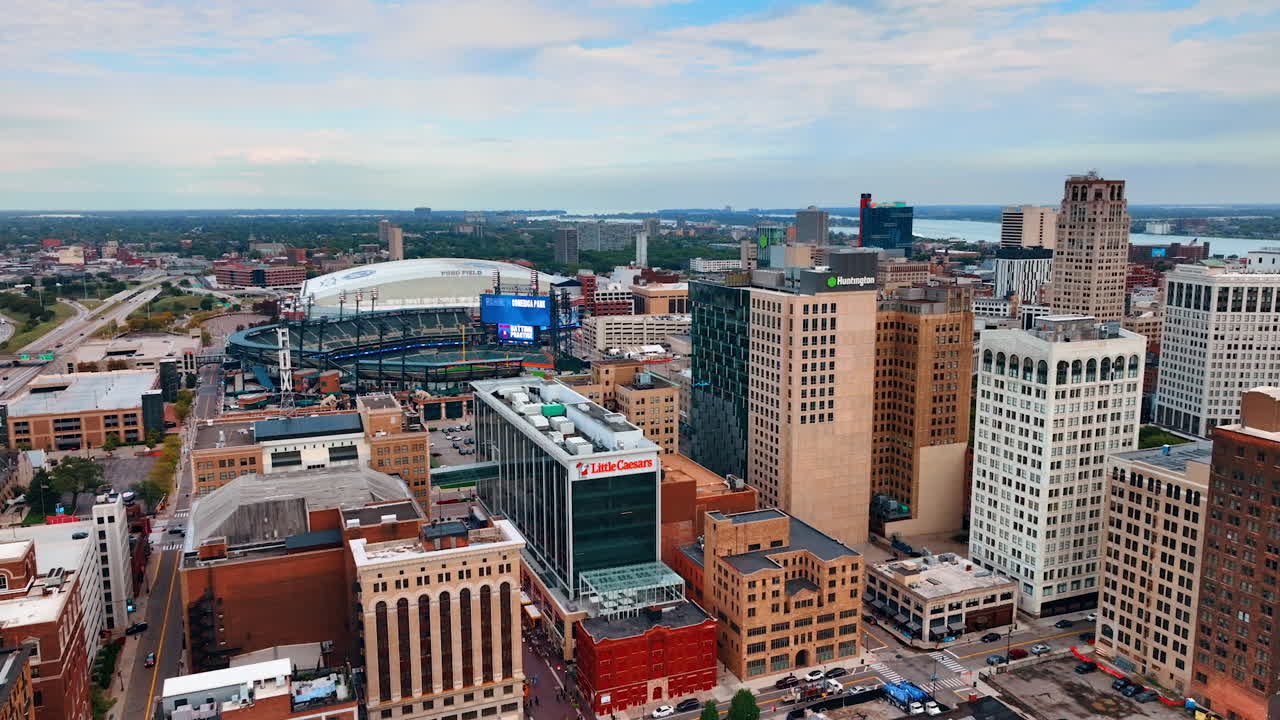Flight over the high-rise buildings of Detroit, Michigan, USA. Sport arena and stadium at backdrop