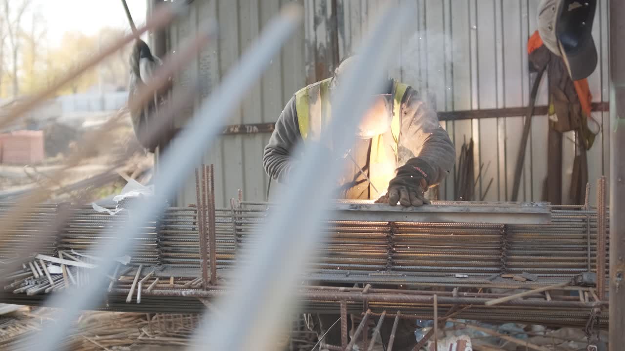 Construction worker welding metal rebar for the pouring of monolithic structure