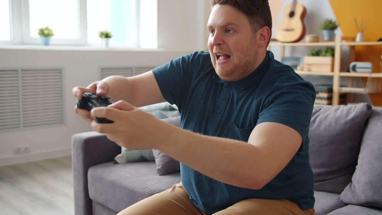 hombre jugando videojuegos en un sofá
