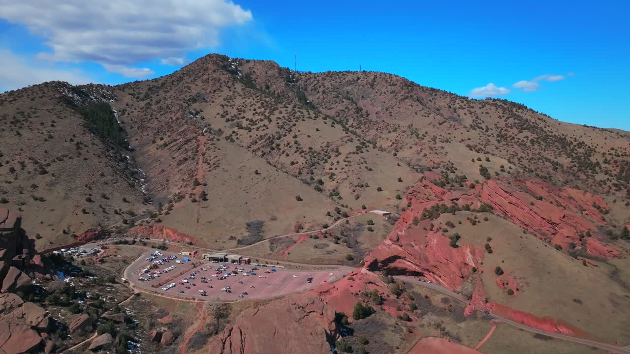 Red Rocks Park and Amphitheater Mount Morrison Colorado aerial drone mid winter no snow walking trails Trading Post sunny blue sky clouds full parking lot cars stairs tourist area forward motion