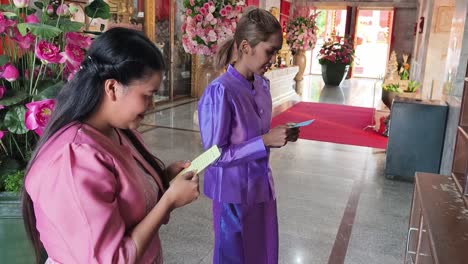 women praying at a thai temple