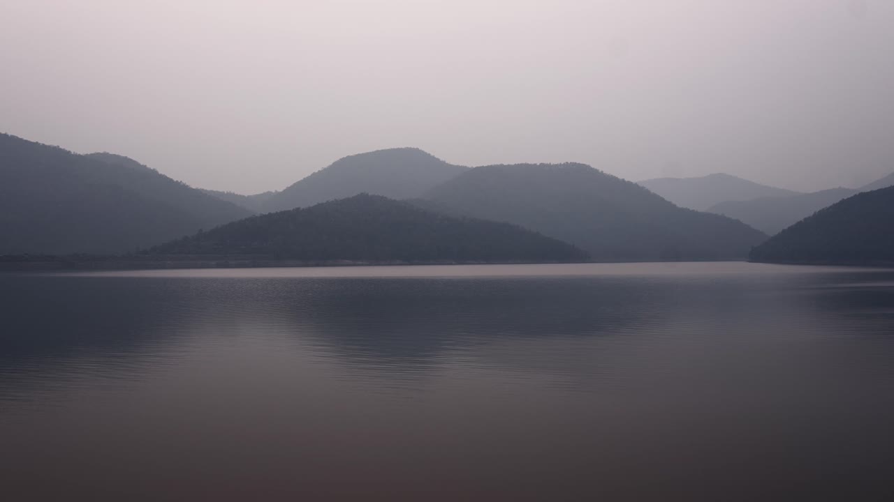 Serene Landscape of a Lake and Misty Mountains