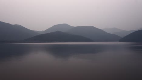 serene landscape of a lake and misty mountains