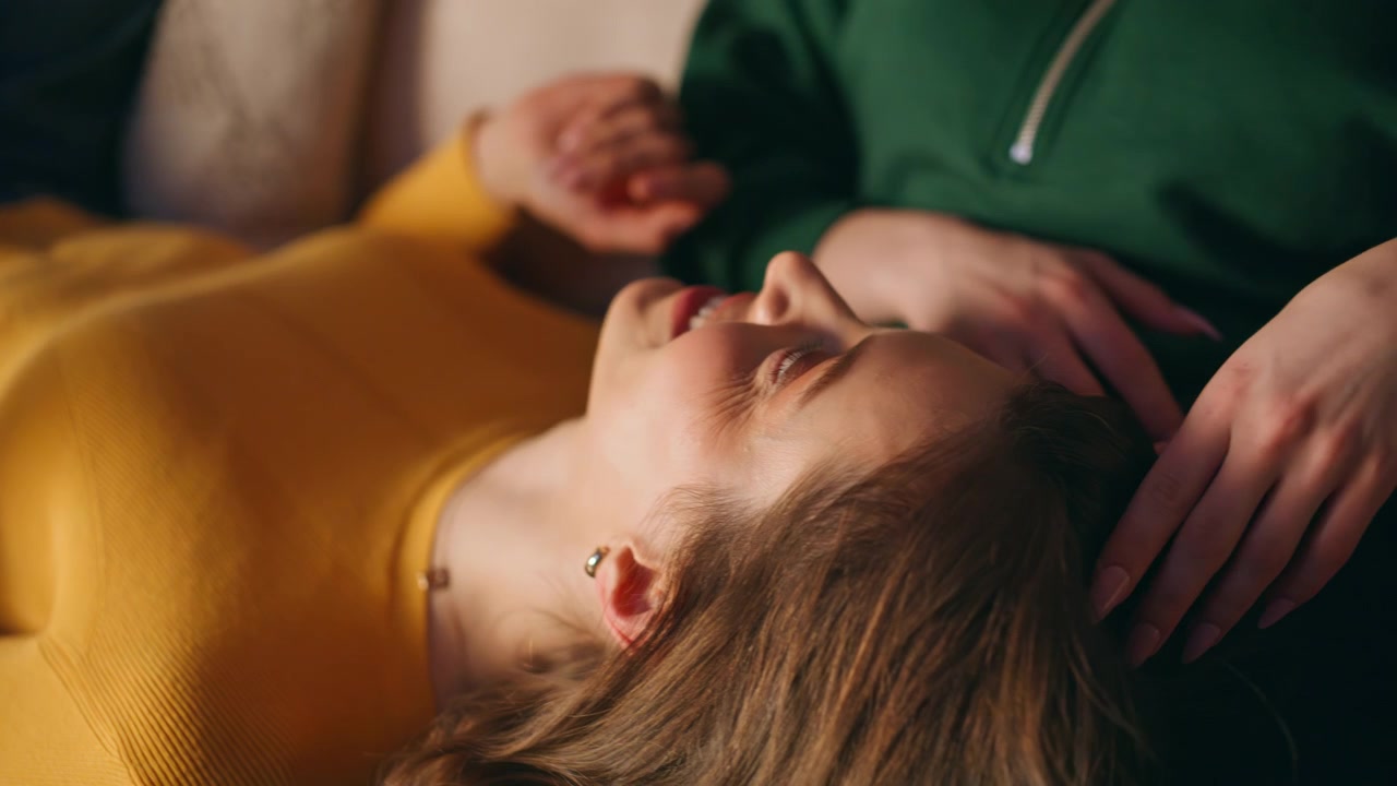 Coppia LGBT felice che chiacchiera a casa nel tempo libero, in primo piano. Due donne lesbiche che si rilassano.