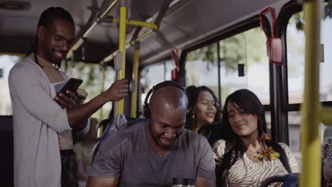 passengers smiling and using mobile devices on a public bus