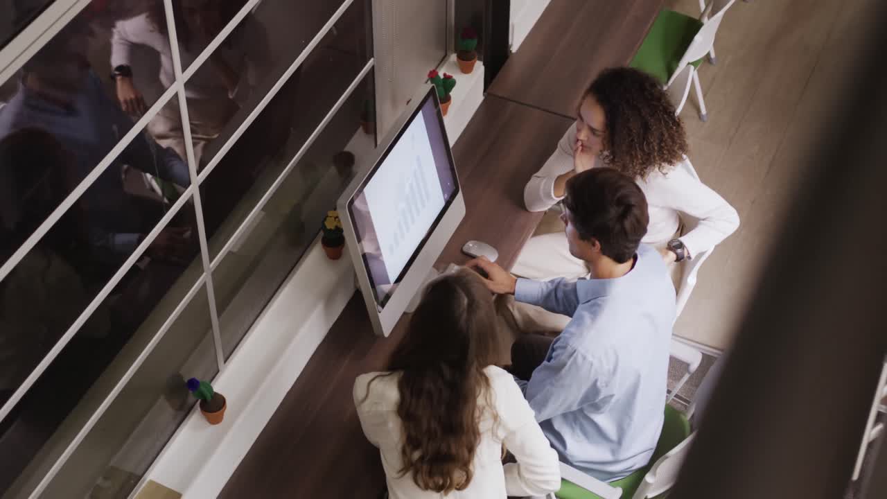 empresarios creativos discutiendo sobre la computadora en una oficina moderna