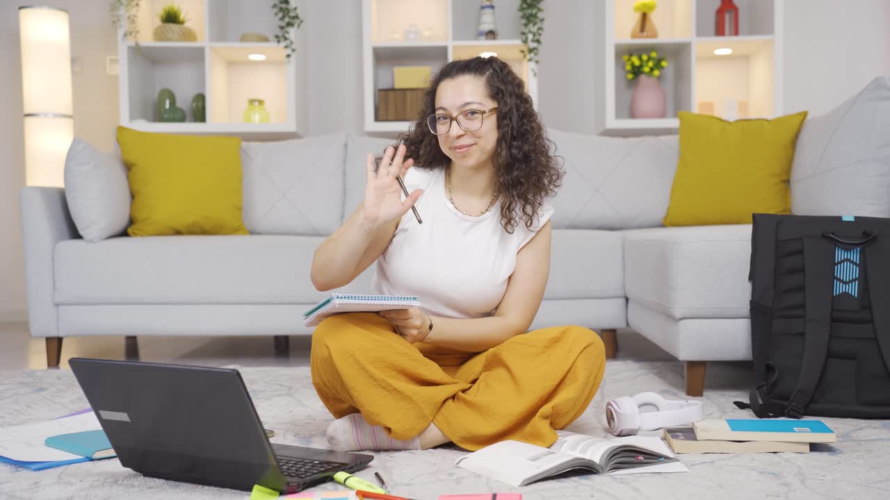 Female student waving to the camera.