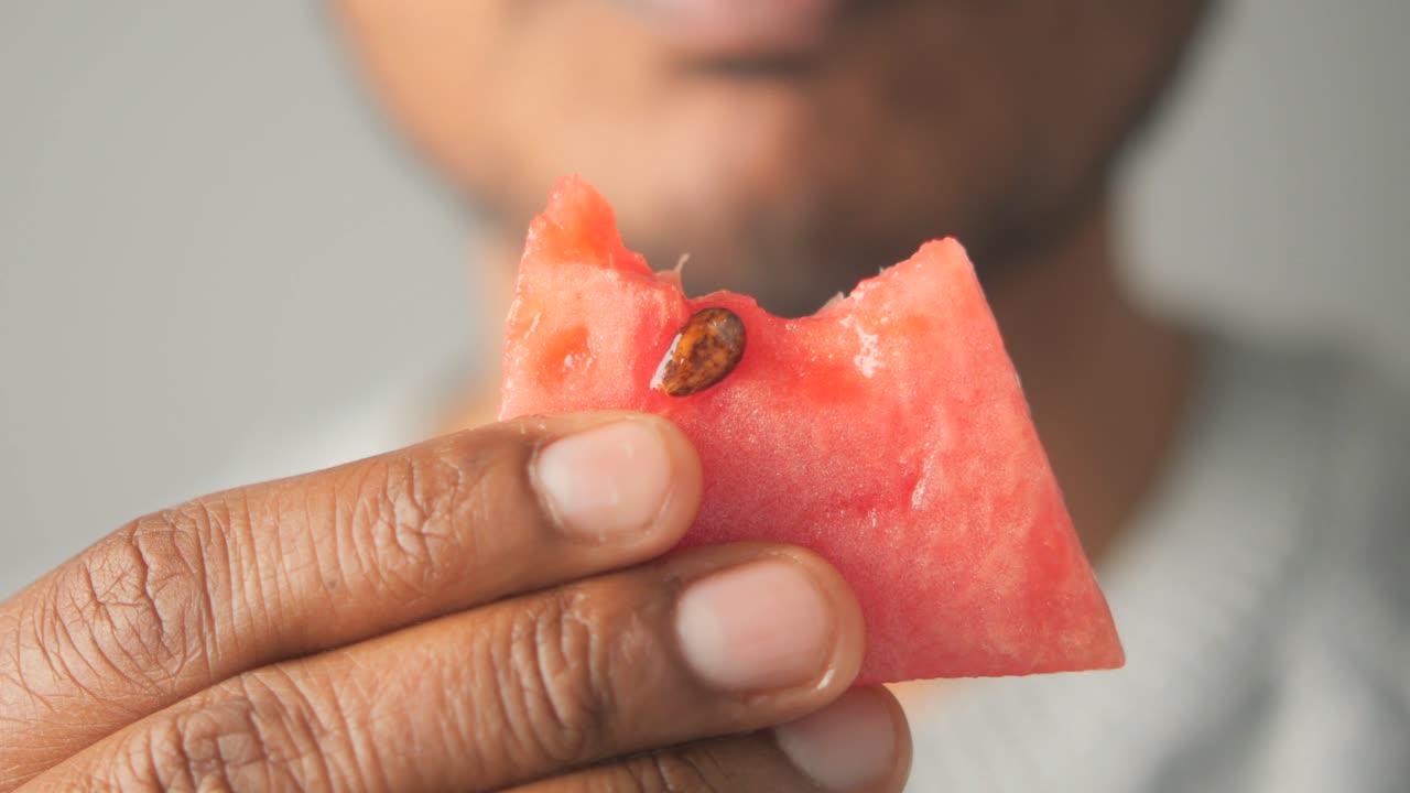Person eating a slice of watermelon