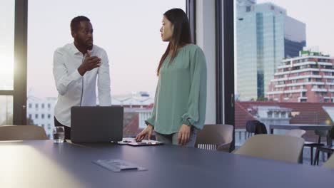 Video-De-Dos-Colegas-Diversos,-Hombres-Y-Mujeres,-Discutiendo-Y-Usando-Una-Computadora-Portátil-En-La-Oficina