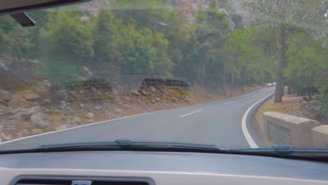 amazing curves of the highway of mallorca, spain forest at mountains with lush greenery having other vehicles moving too