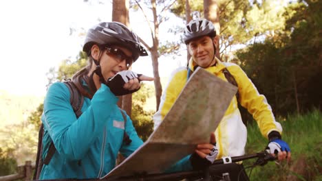 pareja de ciclismo de montaña mirando el mapa