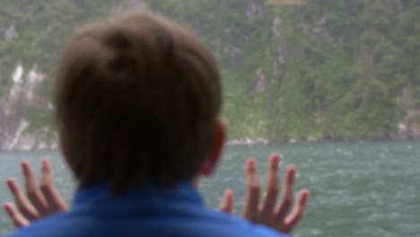 young boy looking out of ship window