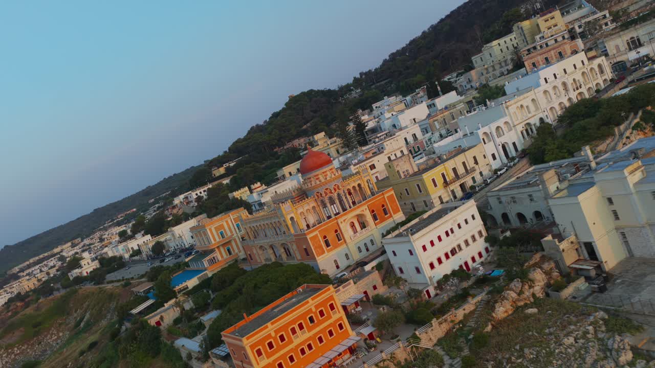 Santa Cesarea Terme, town on Puglian coast, Moorish architecture and beautiful seaside buildings at sunset, Italy. Slow tilting aerial forward