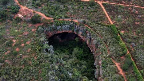 Luftdrohne,-Die-Den-Großen-Lapa-Doce-Höhleneingang-Aus-Bunten-Felsen-Mit-Einem-In-Sich-Geschlossenen-Regenwald-Unten-Im-Chapada-Diamantina-Nationalpark-In-Bahia-Im-Nordosten-Brasiliens-Herunterkippt