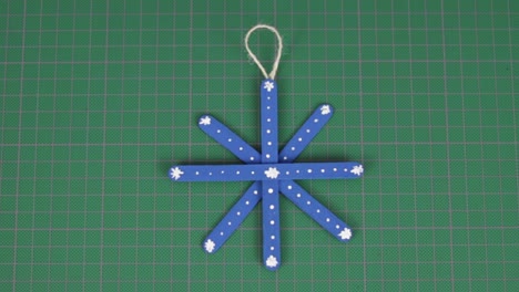 Blue-snowflake-made-of-popsicle-sticks-on-a-cutting-mat