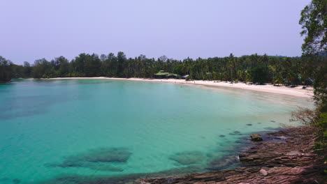 Bungalow-hotel-on-white-sand-Koh-Kood-beach-by-turquoise-sea-lagoon